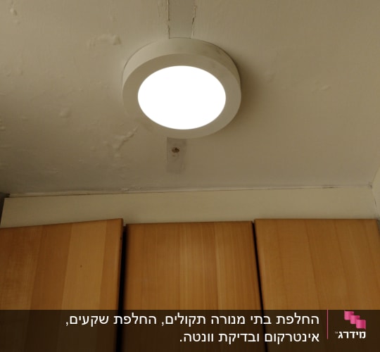 מנורת תקרה עגולה דולקת על תקרה לבנה